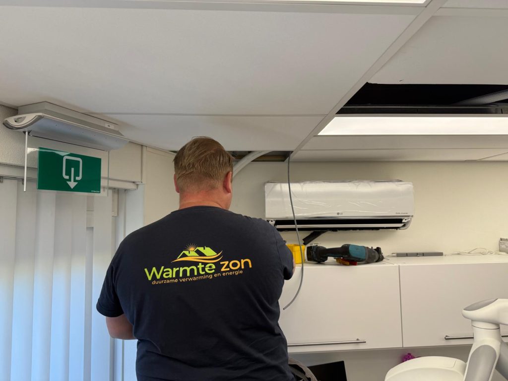 Monteur van Warmte Zon monteert een LG binnenunit aan de wand
